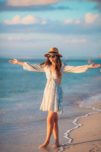 Rear view of woman standing at beach