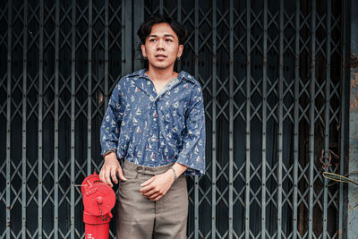 Man standing against closed gate