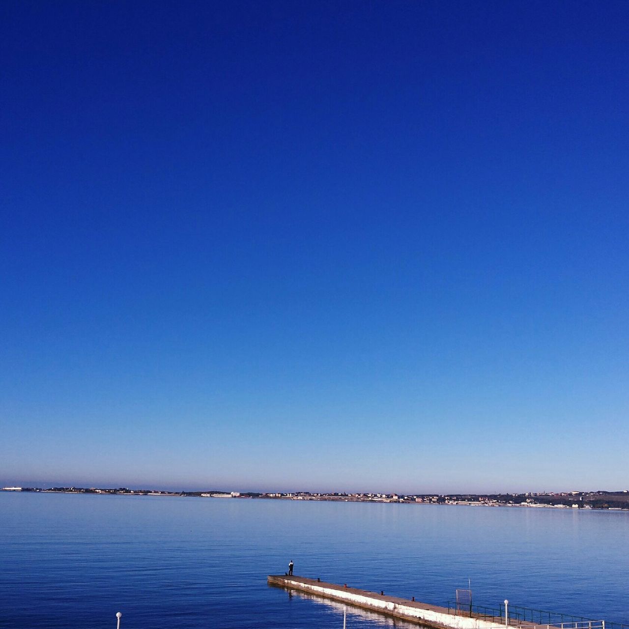 water, blue, clear sky, copy space, sea, waterfront, tranquility, tranquil scene, scenics, nature, beauty in nature, transportation, nautical vessel, outdoors, idyllic, calm, no people, day, rippled, ocean