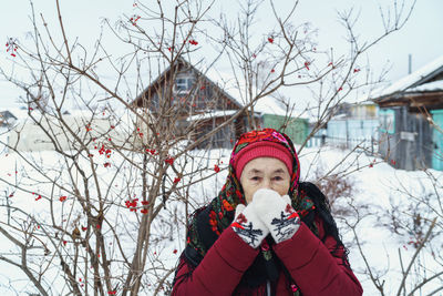 Portrait of woman with bare trees during winter