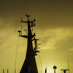 Low angle view of silhouette crane against sky during sunset