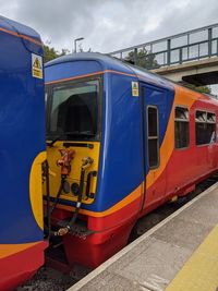 Train at railroad station in city against sky