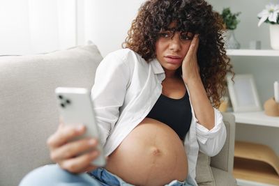 Portrait of young woman using mobile phone at home