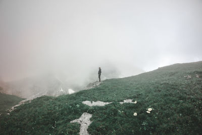 Side view of person standing on field during foggy weather