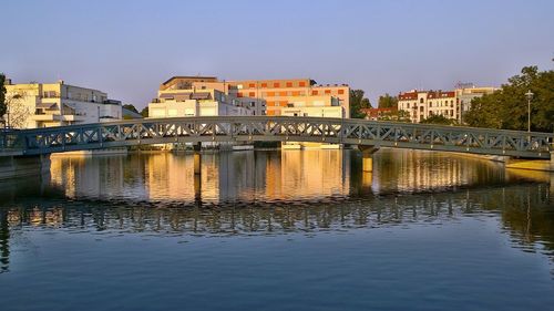 Bridge over river against buildings in city