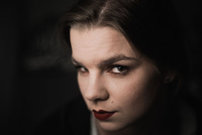 Portrait of a young woman in the shadow with sensual makeup