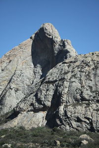 Low angle view of rock formation against sky