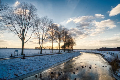 Scenic view of frozen lake against sky during sunset