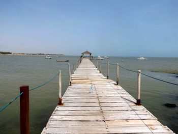 Pier over sea against clear sky