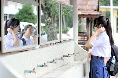 Schoolgirls reflecting in mirror