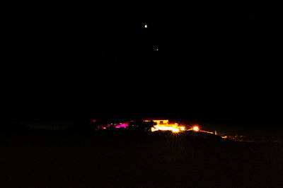 Illuminated city against sky at night