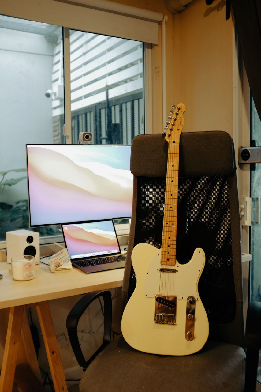 guitar, musical instrument, music, indoors, string instrument, musical equipment, furniture, electric guitar, room, technology, no people, computer, desk, table, plucked string instruments, window, arts culture and entertainment, home interior, chair, seat, business, office, domestic room