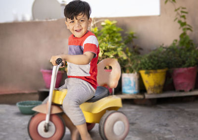 Cute boy riding toy car