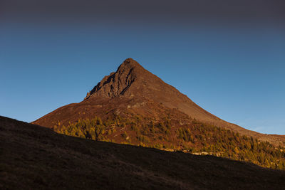 Awesome sunset colors over the top of a volcano-shaped mountain, col quaterna, dolomites, italy