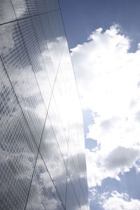 Low angle view of modern building against cloudy sky