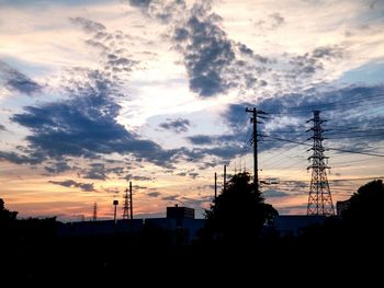 Silhouette of electricity pylon at sunset