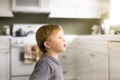 Close-up of boy looking through window