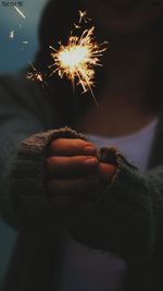 Close-up of hand holding sparkler at night