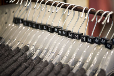 Close-up of coathangers on rack at store