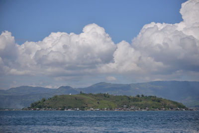 Scenic view of sea and mountains against sky