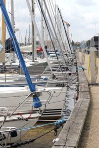 Sailboats moored on sea against sky