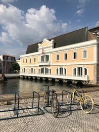 Bicycles by canal against buildings in city