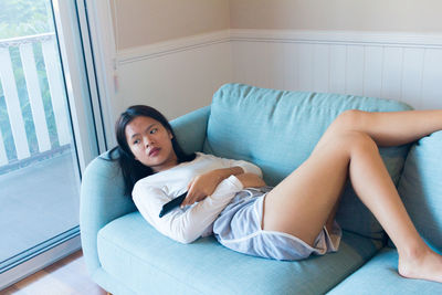 Asian teenage girl lay down boring watch television