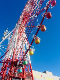 Low angle view of ferris wheel against clear blue sky