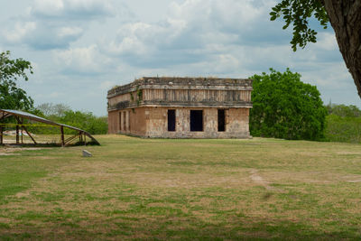 View of castle on field against cloudy sky