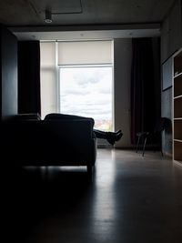 Person relaxing on sofa by window at home