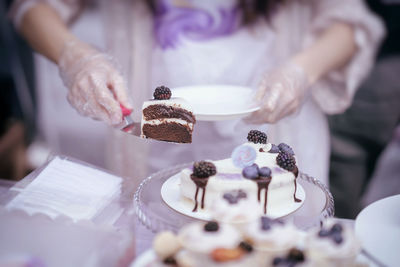 Midsection of woman holding cake slice