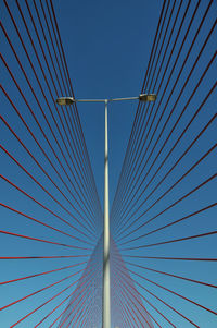 Low angle view of suspension bridge against clear blue sky