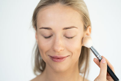 Portrait of young woman holding eyeglasses