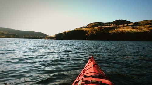 Cropped image of kayak over lake against clear sky