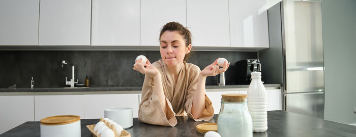 Portrait of young woman drinking water at home