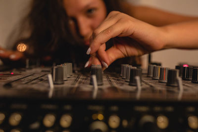 Close-up of fashionable young woman playing music at home