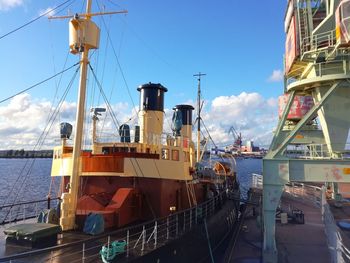 Ship moored at harbor against sky