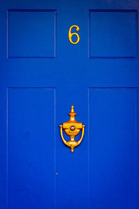 House number 6 on a blue wooden front door