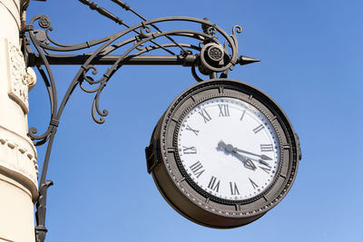 Low angle view of clock against clear sky
