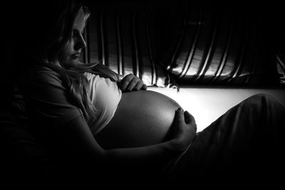 Side view of pregnant woman lying at home