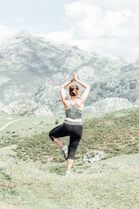 Full length of young woman standing on mountain