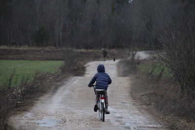 Rear view of boy riding bicycle