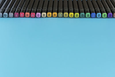 High angle view of colored pencils against blue background