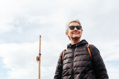 Man wearing sunglasses standing against sky