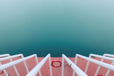 Close-up of hand by sea against blue sky