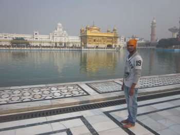 Portrait of man standing by river in city