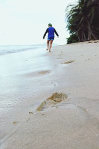 Rear view of man walking on beach