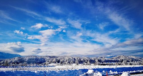 Scenic view of snowcapped field against sky