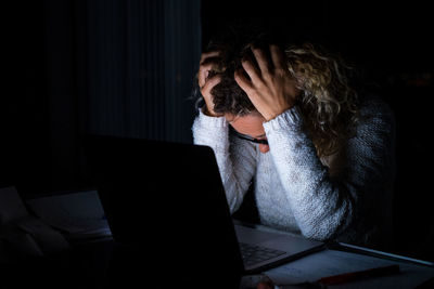 Woman using mobile phone while sitting on table