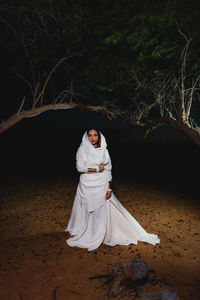 Portrait of woman standing at desert 